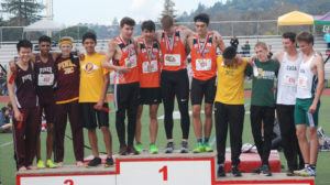 Athlete prepares for pole vault on a track with others watching.