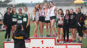 Athlete prepares for pole vault on a track with others watching.