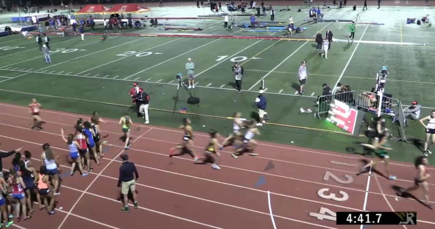Athlete prepares for pole vault on a track with others watching.