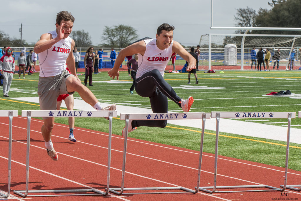 Athlete prepares for pole vault on a track with others watching.