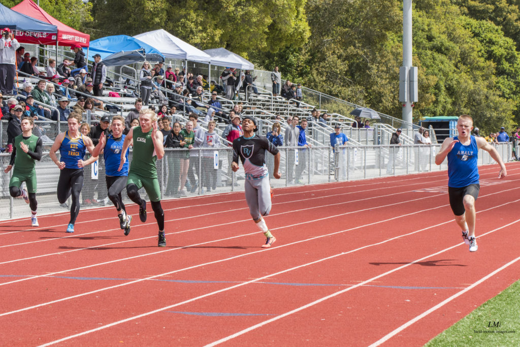 Athlete prepares for pole vault on a track with others watching.