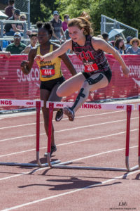 Athlete prepares for pole vault on a track with others watching.