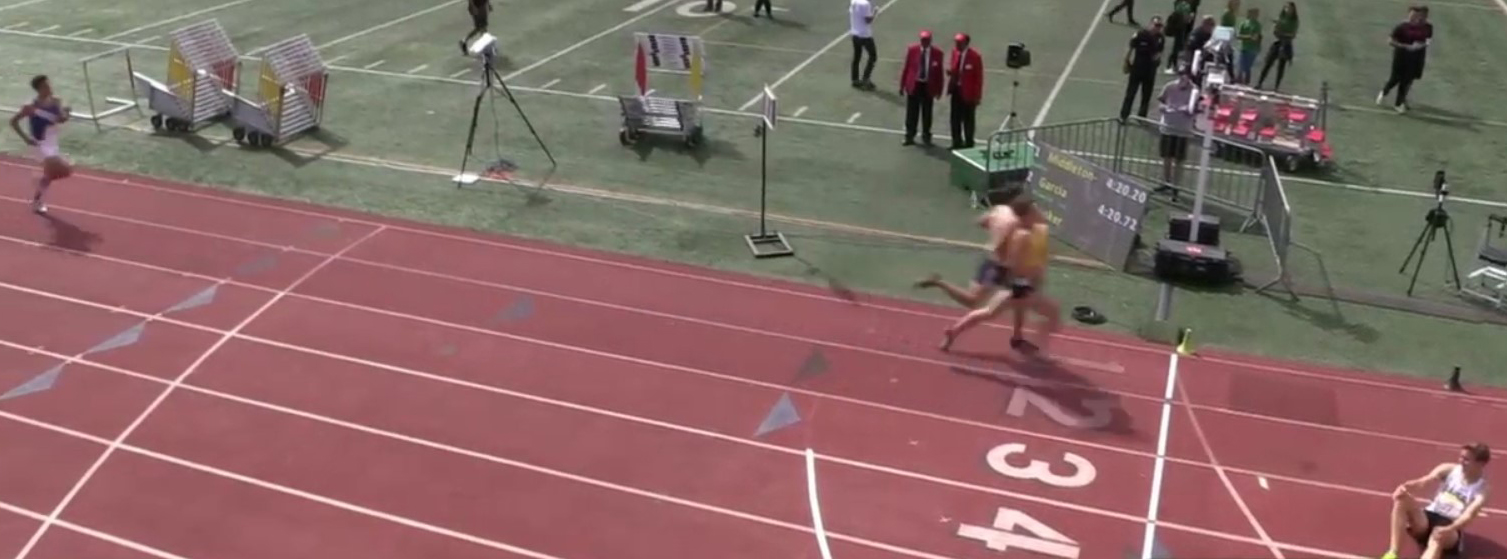 Athlete prepares for pole vault on a track with others watching.