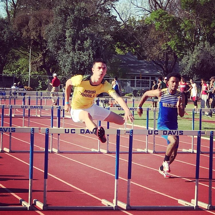 Athlete prepares for pole vault on a track with others watching.