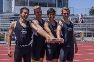 Athlete prepares for pole vault on a track with others watching.