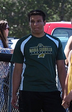 Athlete prepares for pole vault on a track with others watching.