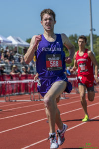 Athlete prepares for pole vault on a track with others watching.