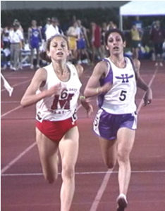 Athlete prepares for pole vault on a track with others watching.