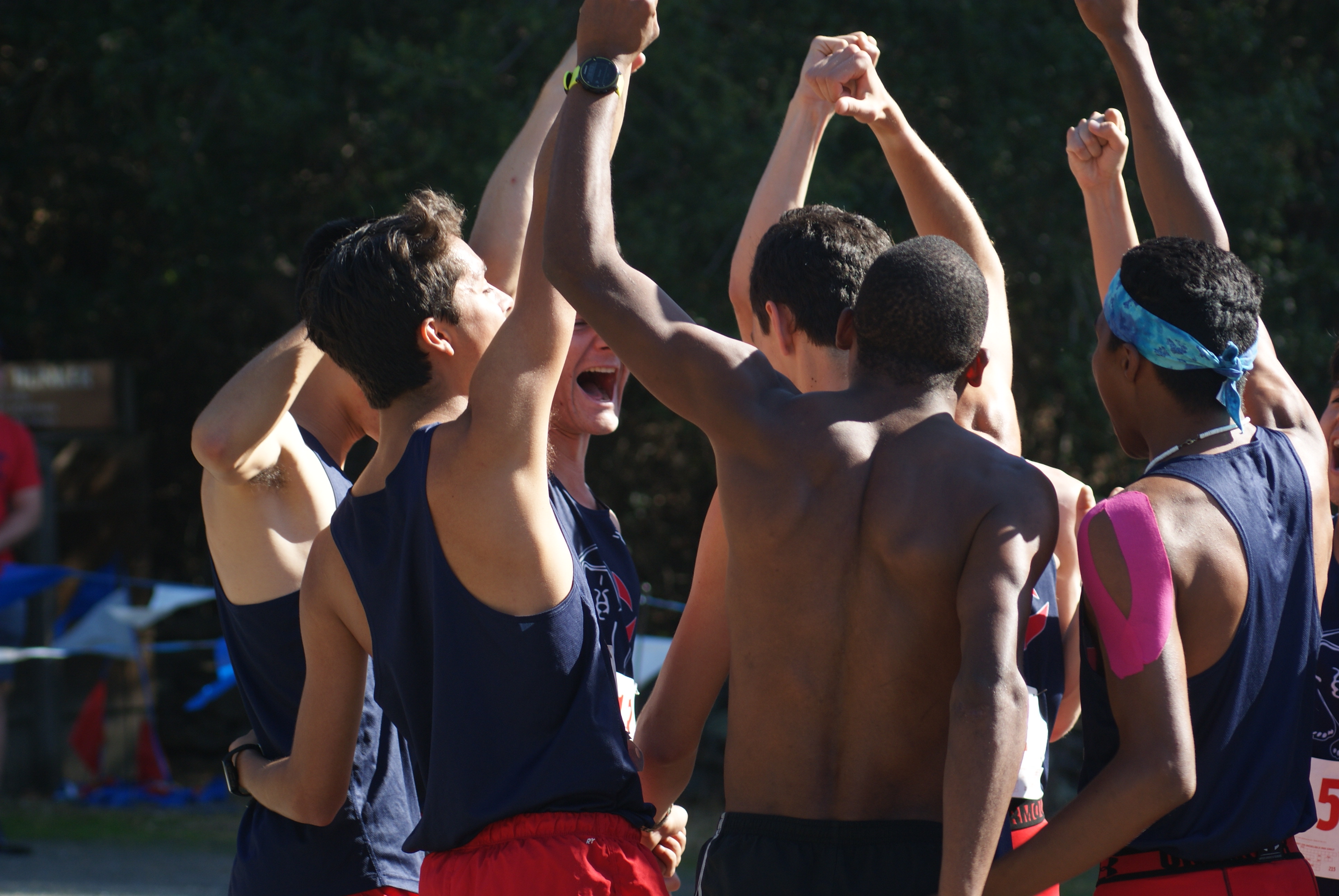 Athlete prepares for pole vault on a track with others watching.