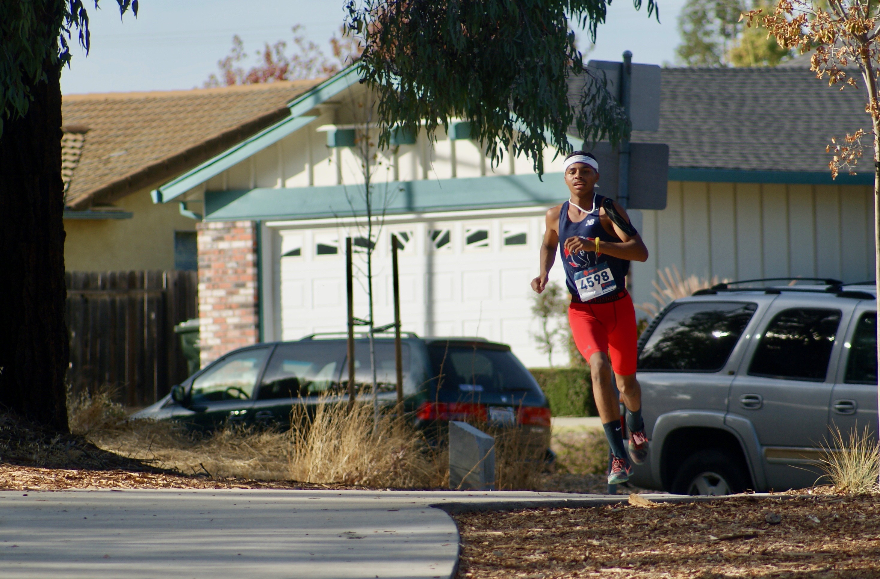 Athlete prepares for pole vault on a track with others watching.