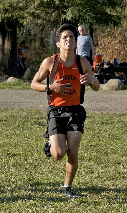 Athlete prepares for pole vault on a track with others watching.