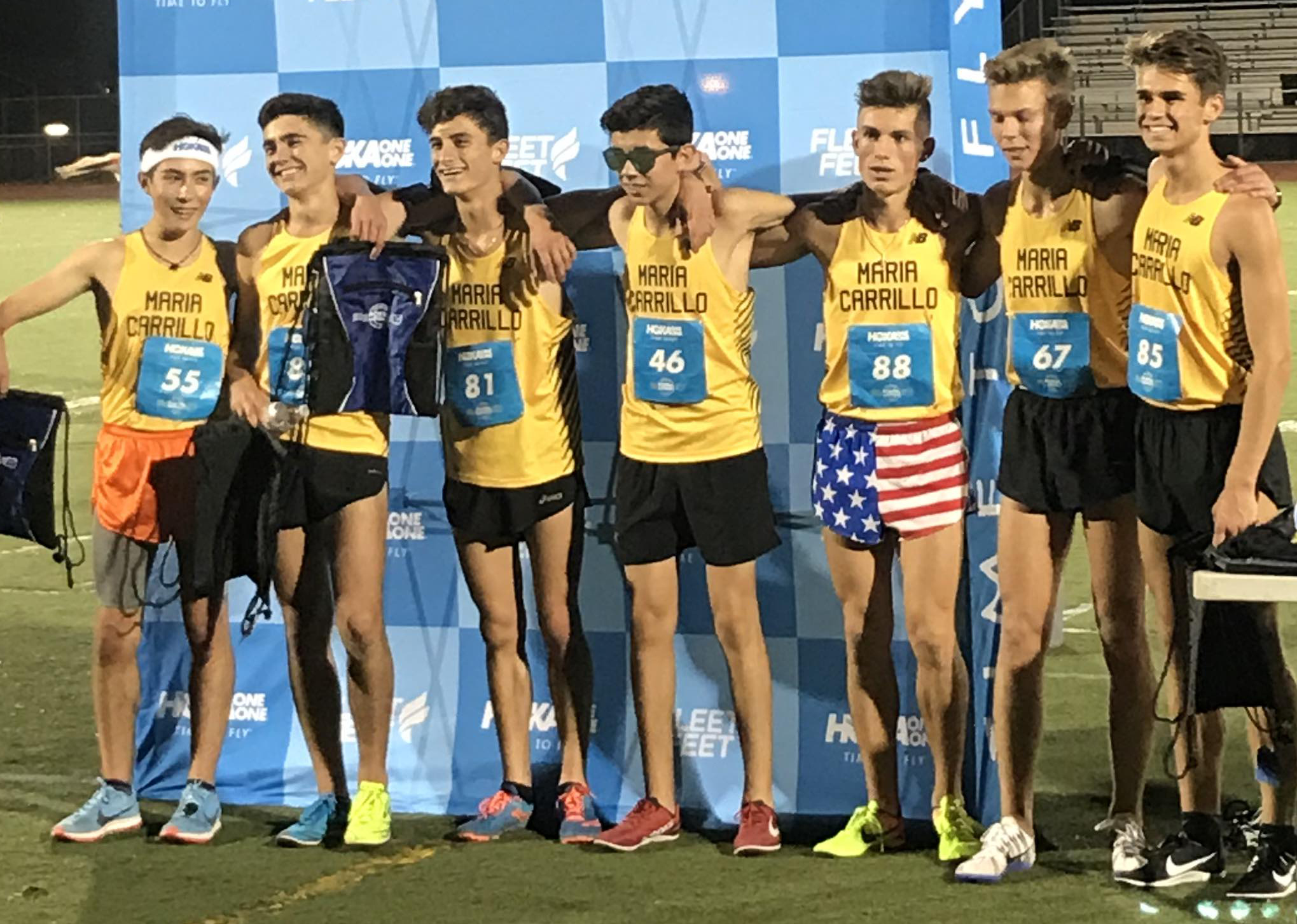 Athlete prepares for pole vault on a track with others watching.