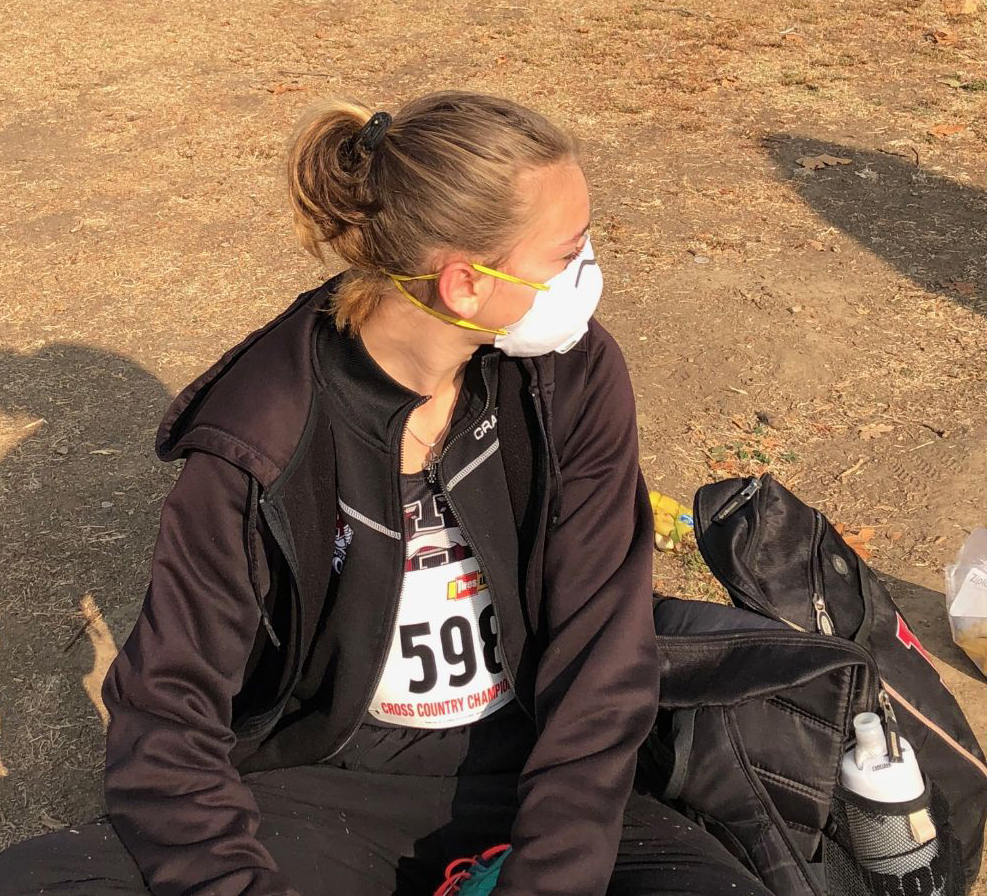Athlete prepares for pole vault on a track with others watching.