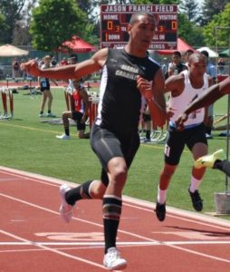 Athlete prepares for pole vault on a track with others watching.