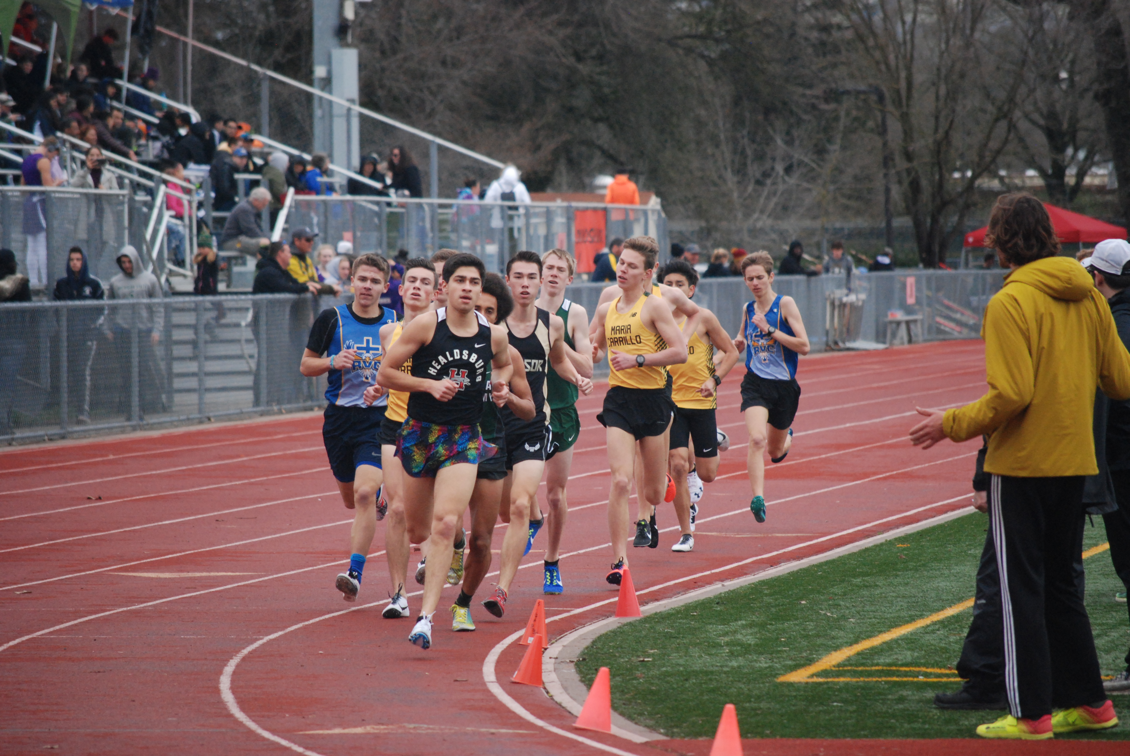 Athlete prepares for pole vault on a track with others watching.