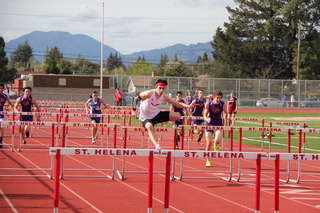 Athlete prepares for pole vault on a track with others watching.