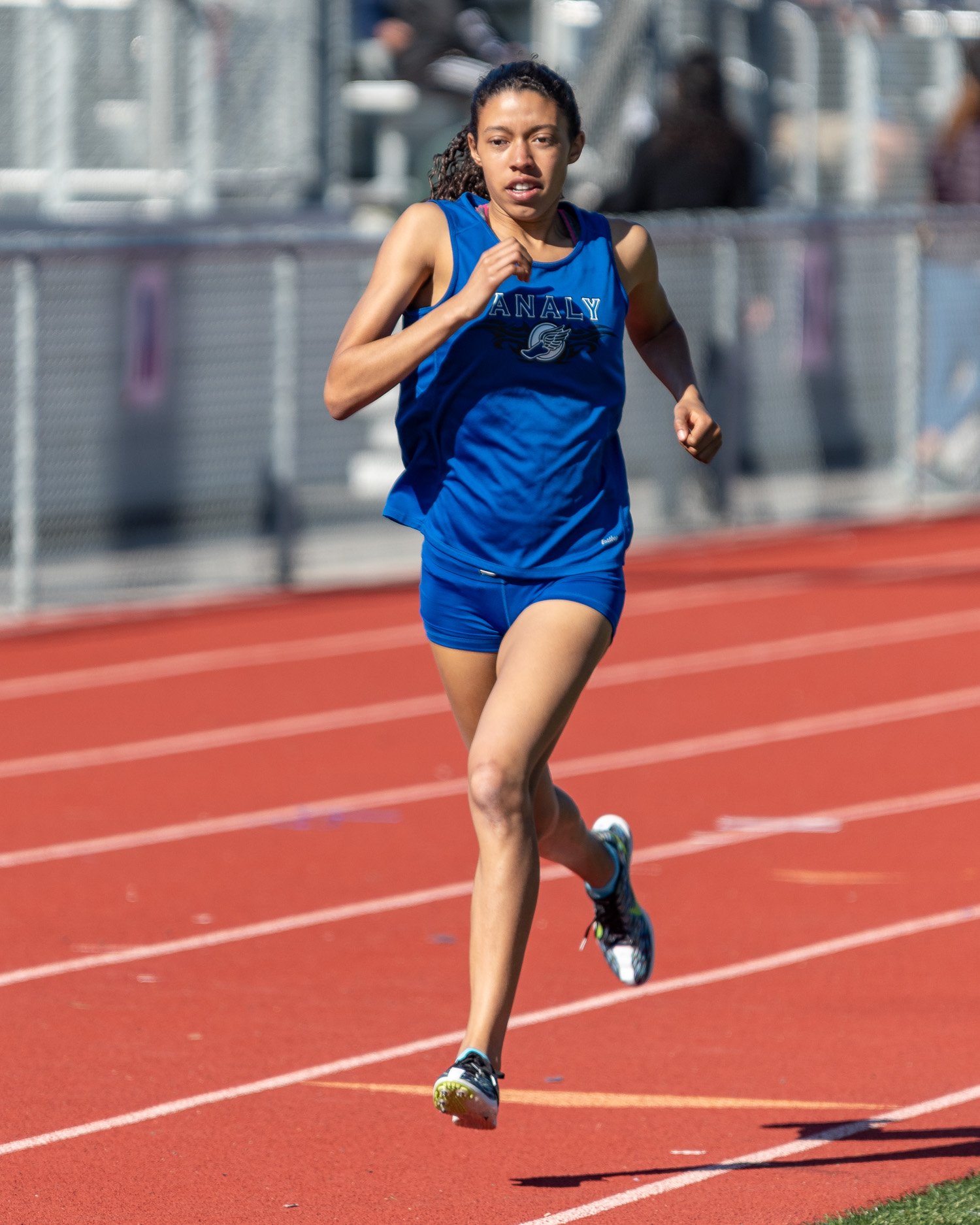 Athlete prepares for pole vault on a track with others watching.