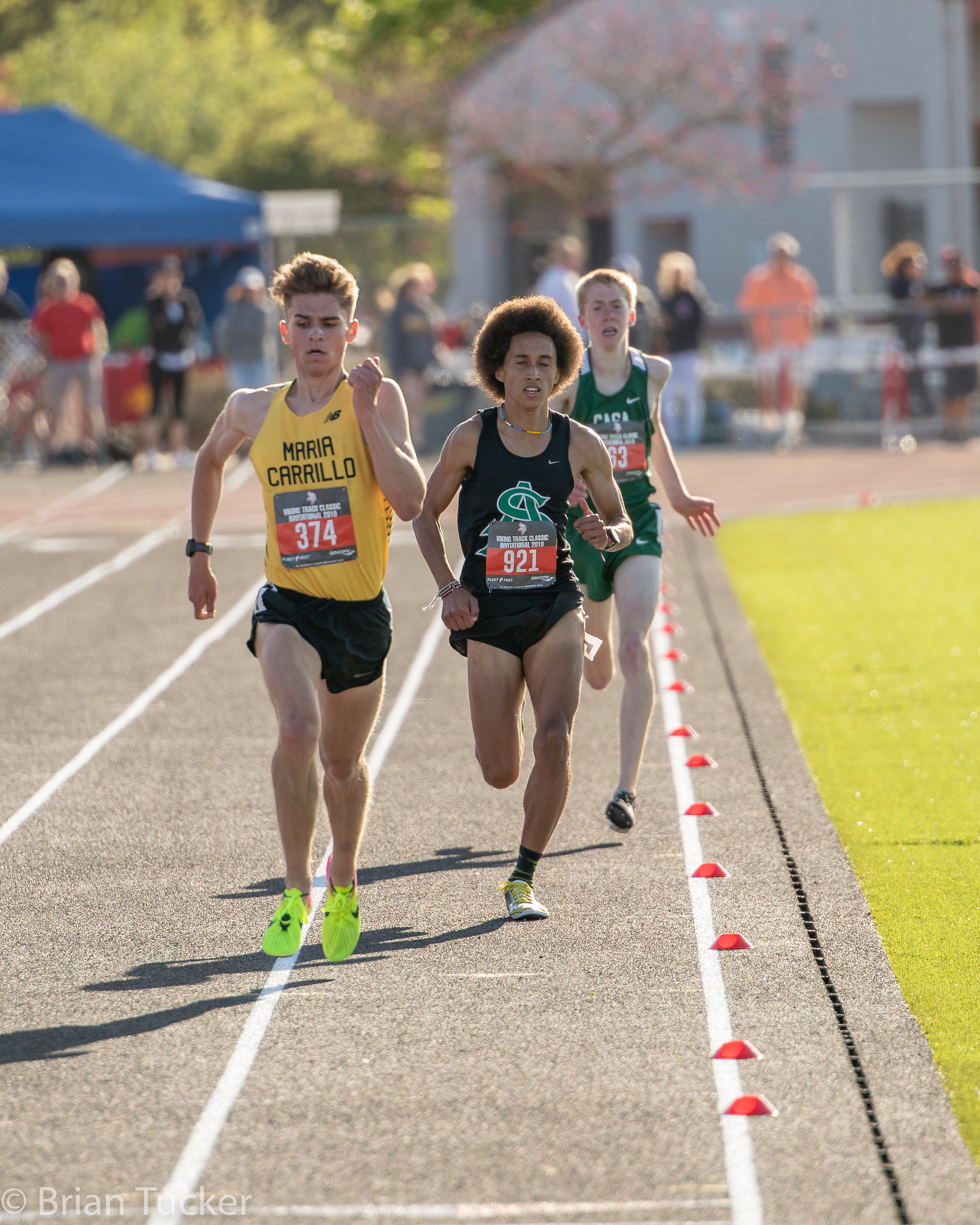 Athlete prepares for pole vault on a track with others watching.