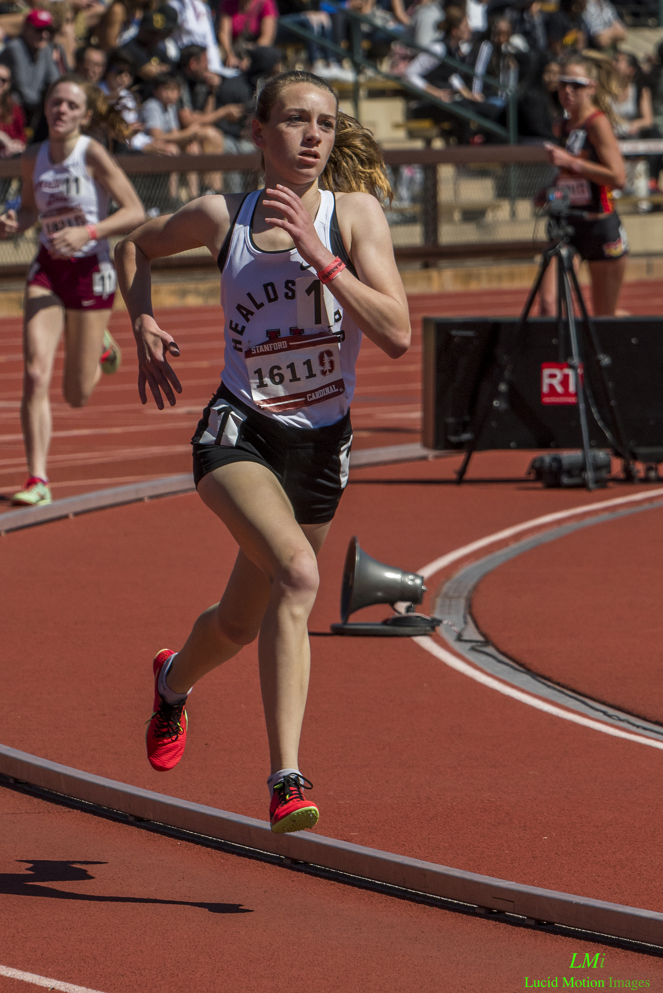 Athlete prepares for pole vault on a track with others watching.