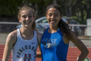 Athlete prepares for pole vault on a track with others watching.
