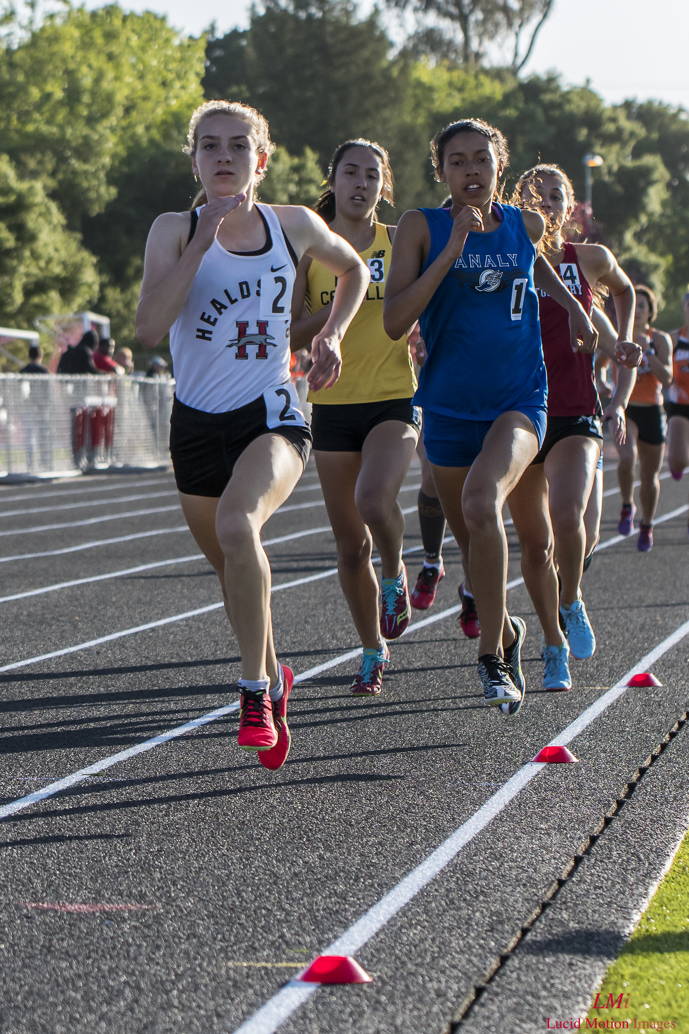 Athlete prepares for pole vault on a track with others watching.