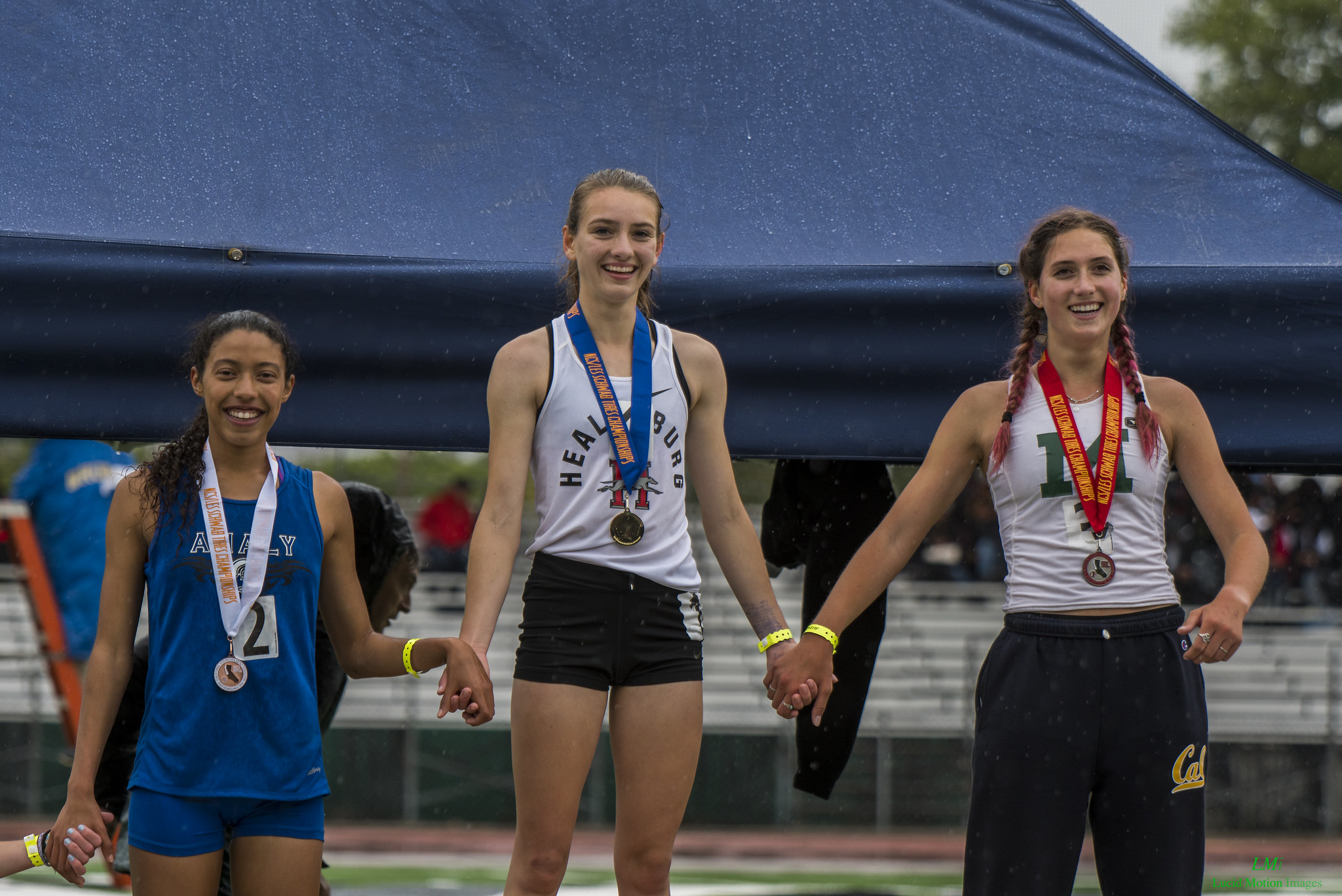 Athlete prepares for pole vault on a track with others watching.