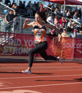 Athlete prepares for pole vault on a track with others watching.