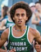 Athlete prepares for pole vault on a track with others watching.
