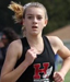 Athlete prepares for pole vault on a track with others watching.