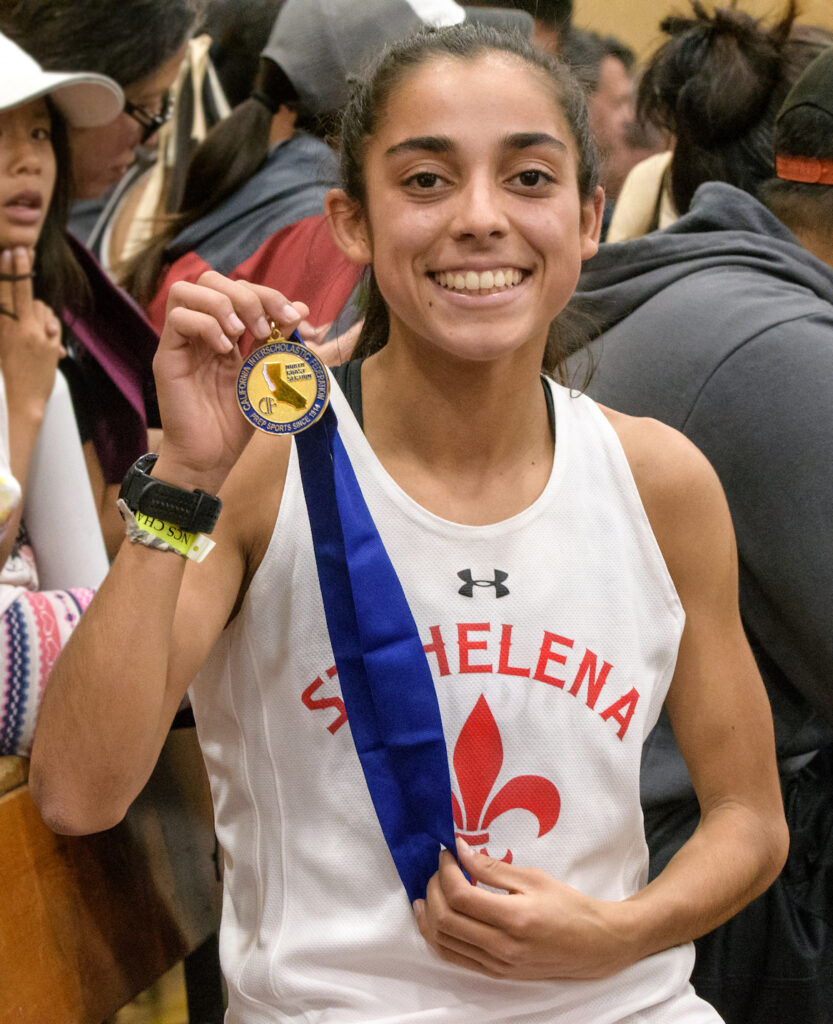 Athlete prepares for pole vault on a track with others watching.