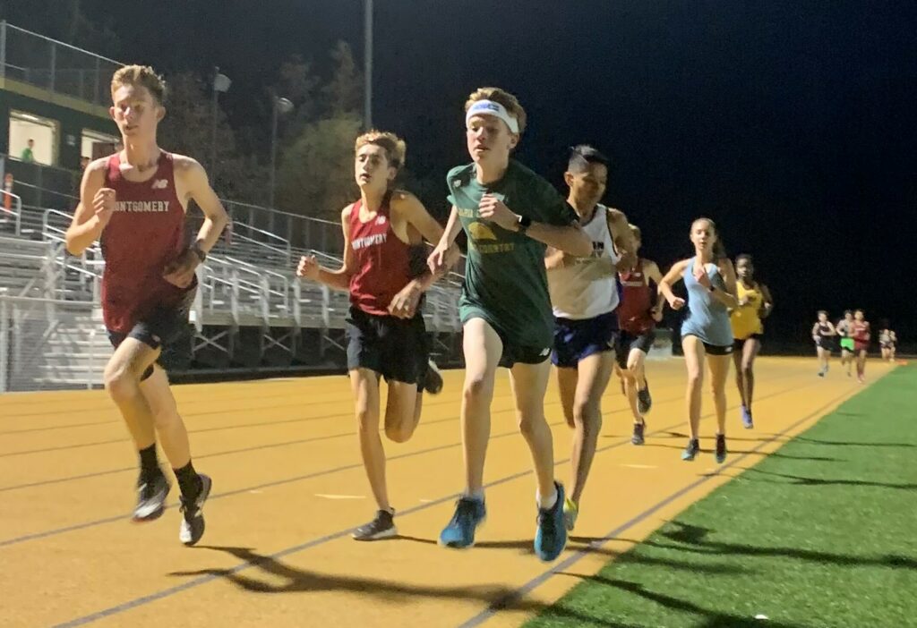 Athlete prepares for pole vault on a track with others watching.