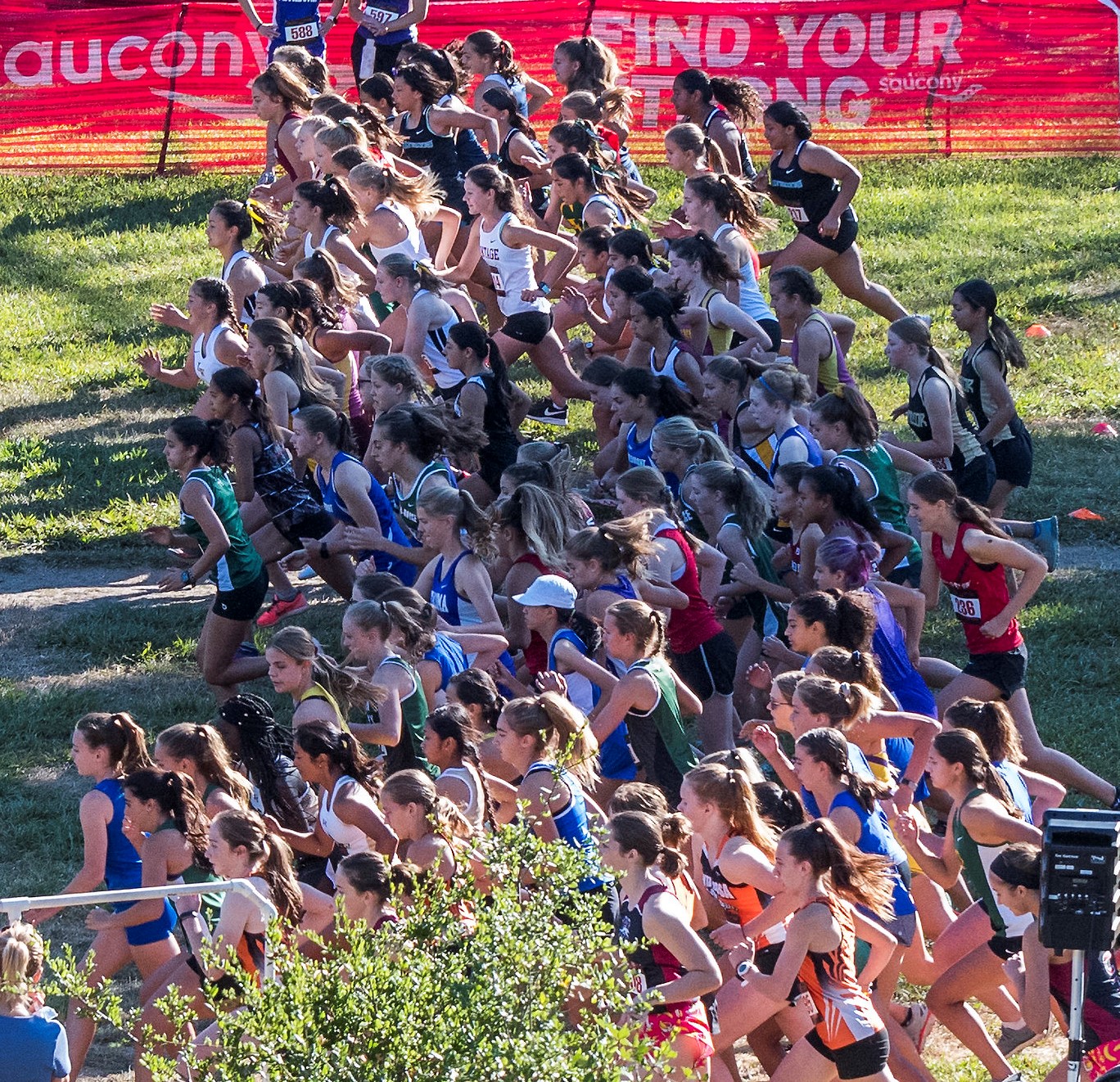 Athlete prepares for pole vault on a track with others watching.