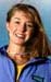 Athlete prepares for pole vault on a track with others watching.