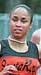 Athlete prepares for pole vault on a track with others watching.